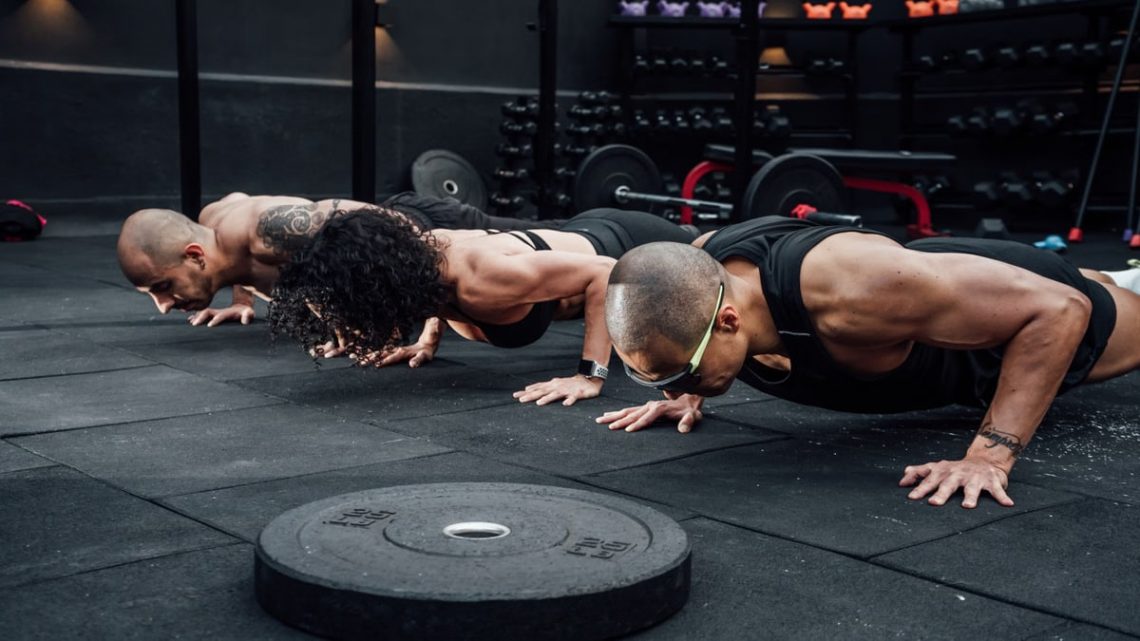Group workout session in a Mexico City gym with athletes doing push-ups.